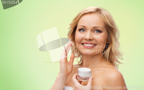 Image of happy woman applying cream to her face