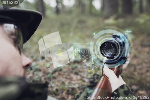 Image of close up of soldier or sniper with gun in forest