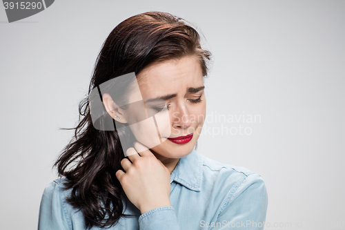 Image of The portrait of a crying young lonely woman on gray