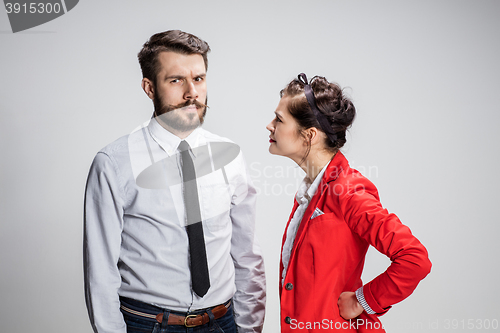 Image of The business man and woman conflicting on a gray background