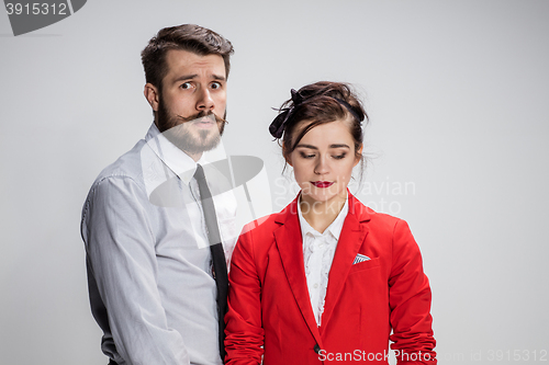 Image of The business man and woman conflicting on a gray background