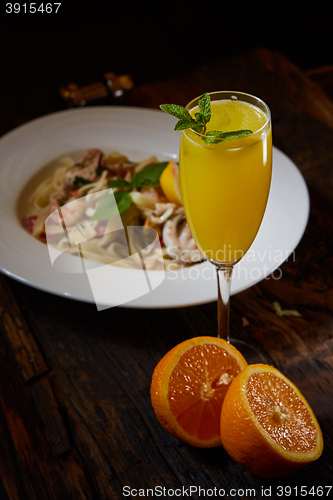 Image of Orange cocktail on rustic wooden table