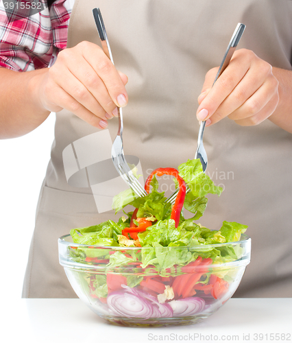 Image of Cook is mixing salad