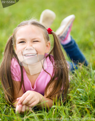 Image of Portrait of a little girl laying on green grass