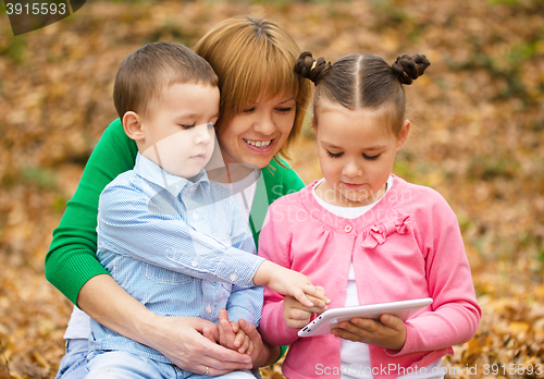 Image of Mother is reading book with her daughter and son