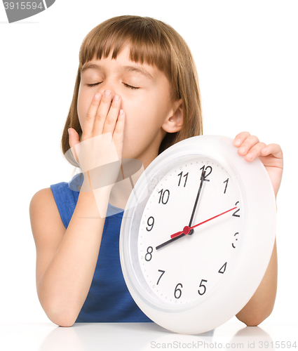 Image of Little girl is holding big clock