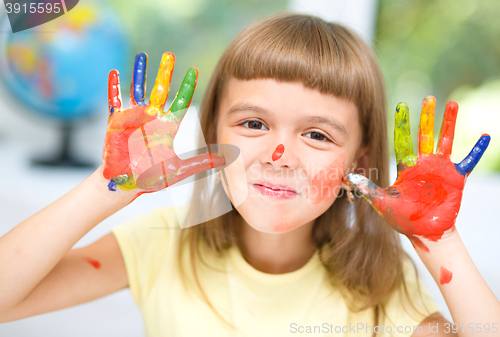 Image of Portrait of a cute girl playing with paints