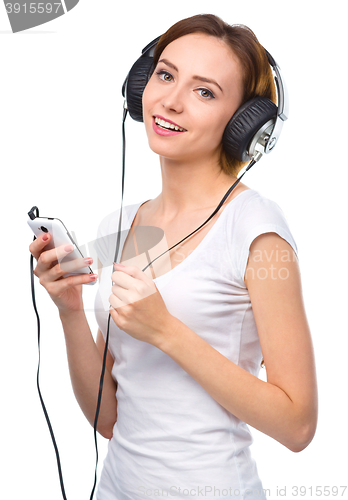 Image of Young woman enjoying music using headphones