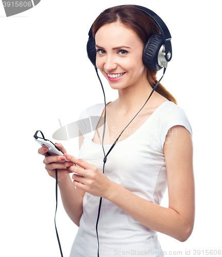 Image of Young woman enjoying music using headphones