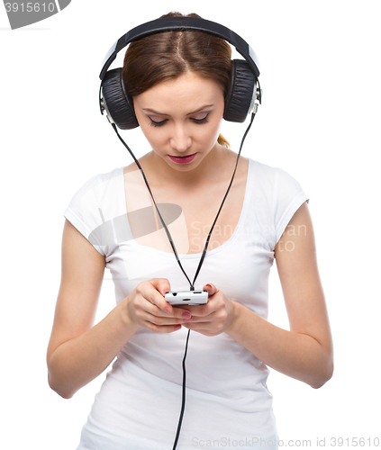 Image of Young woman enjoying music using headphones