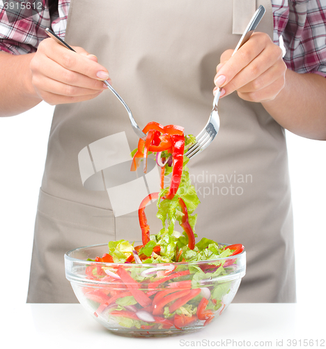 Image of Cook is mixing salad