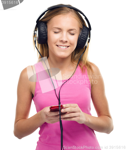 Image of Teen girl enjoying music using headphones