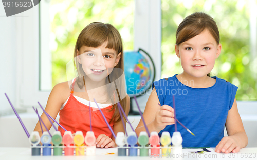 Image of Little girls are painting with gouache