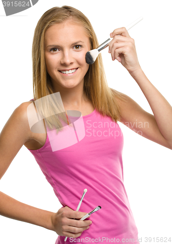 Image of Teen girl is applying makeup