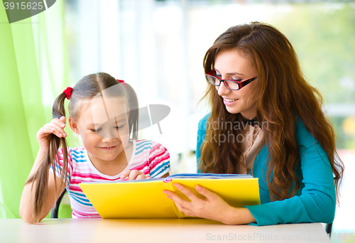 Image of Mother is reading book with her daughter