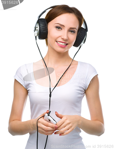 Image of Young woman enjoying music using headphones