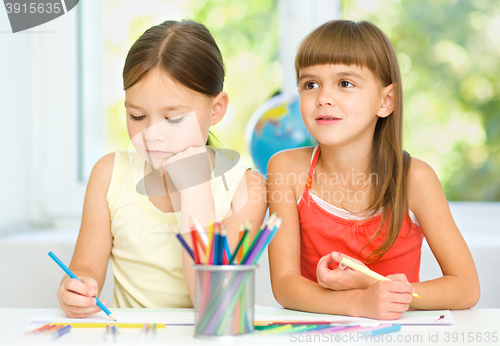 Image of Little girls are drawing using pencils