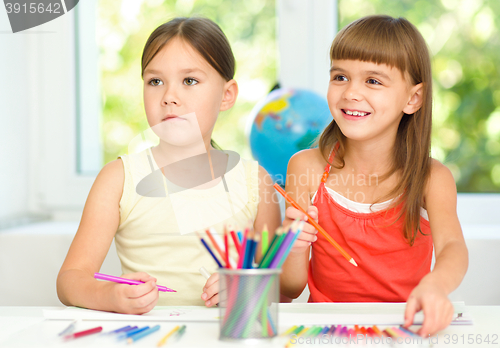 Image of Little girls are drawing using pencils