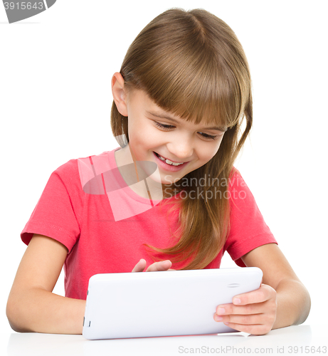Image of Young cheerful girl is using tablet