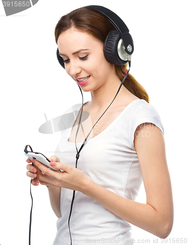 Image of Young woman enjoying music using headphones