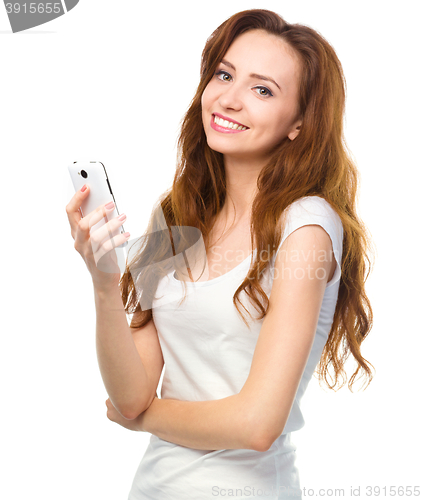 Image of Young woman is typing sms message on her phone