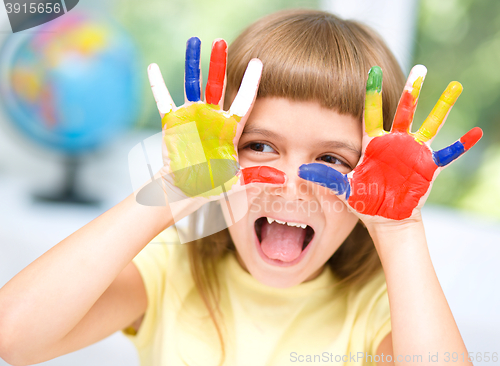 Image of Portrait of a cute girl playing with paints