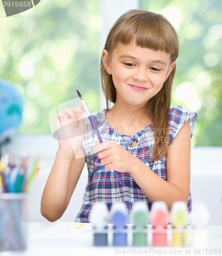 Image of Little girl is painting with gouache