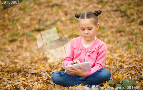 Image of Little girl is reading from tablet