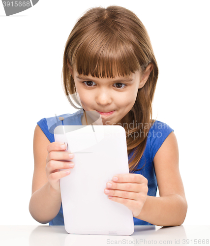 Image of Young cheerful girl is using tablet