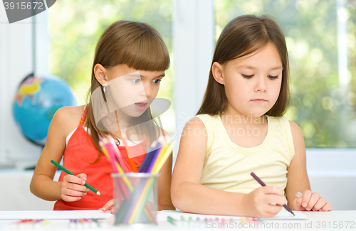 Image of Little girls are drawing using pencils