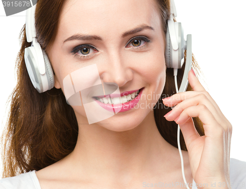 Image of Lovely young woman is talking to customers