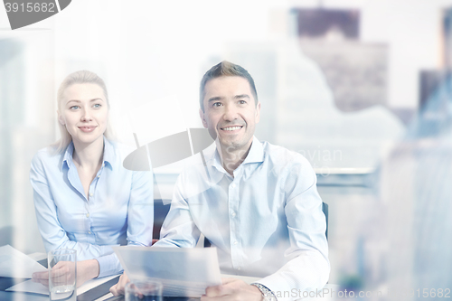 Image of group of smiling businesspeople meeting in office