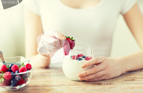 Image of close up of woman hands with yogurt and berries