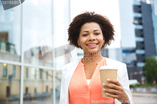 Image of happy african businesswoman with coffee in city
