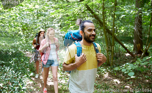 Image of group of smiling friends with backpacks hiking