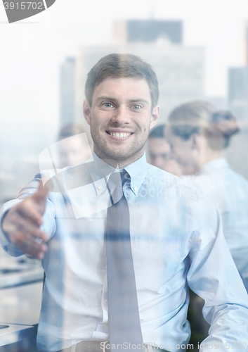 Image of group of smiling businesspeople meeting in office