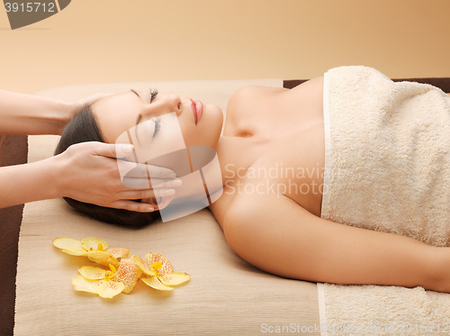 Image of woman in spa salon lying on the massage desk