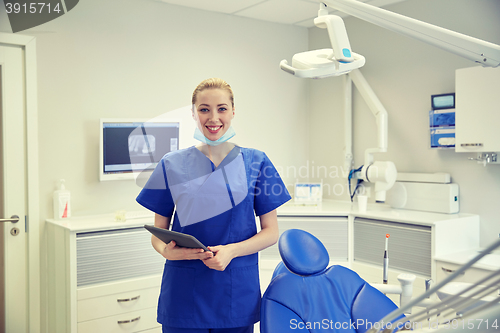 Image of happy female dentist with tablet pc at clinic