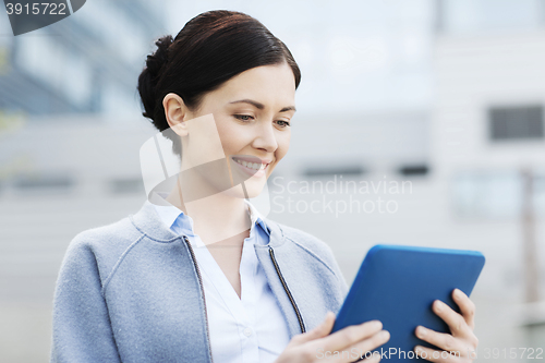 Image of smiling business woman with tablet pc in city