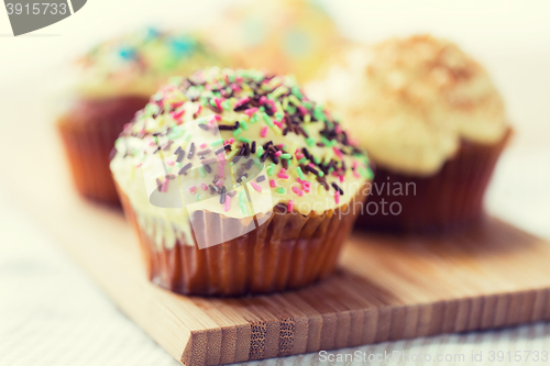 Image of close up of glazed cupcakes or muffins on table