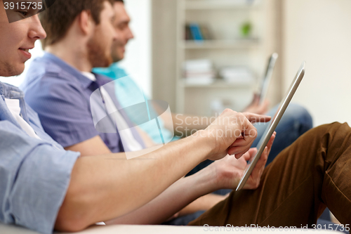 Image of close up of happy friends with tablet pc at home