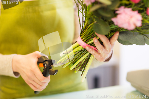 Image of close up of florist woman with flowers and pruner