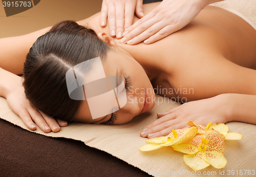 Image of woman in spa salon lying on the massage desk