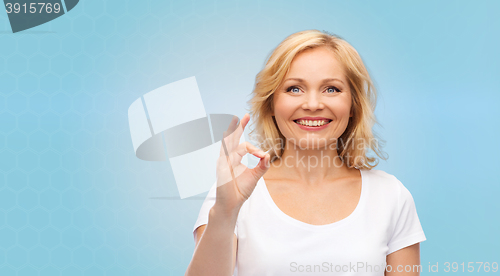 Image of happy woman in white t-shirt showing ok hand sign