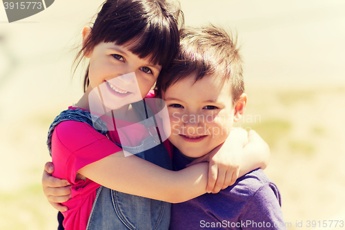 Image of two happy kids hugging outdoors