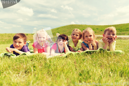 Image of group of kids lying on blanket or cover outdoors