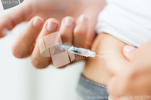 Image of woman with syringe making insulin injection