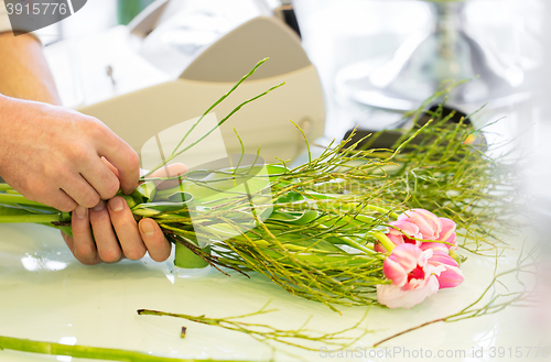 Image of close up of man making bunch at flower shop