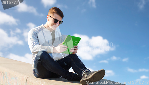 Image of happy young man with tablet pc outdoors