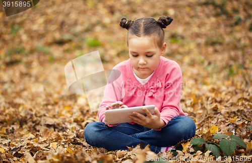 Image of Little girl is reading from tablet